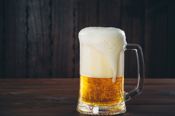 Mug of beer on the wooden background. Beautiful background of the Oktoberfest