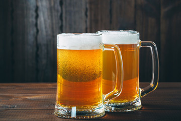 Two Mug of beer on the wooden background. Beautiful background of the Oktoberfest