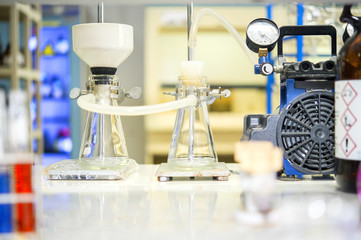 Chemical filtration with Buchner funnel bushings using a vacuum pump, in chemical laboratories.