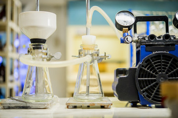 Chemical filtration with Buchner funnel bushings using a vacuum pump, in chemical laboratories.