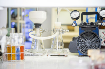 Chemical filtration with Buchner funnel bushings using a vacuum pump, in chemical laboratories.