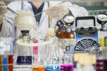 Scientists are using a filter clamp in a buchner funnel for chemical filtration in chemical laboratories, Close up Focus on Buchner funnel.