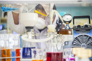 Scientists pour a solution to filter into the filter Buchner funnel to separate the solution from the sediment through a vacuum pump. in the chemical laboratory.