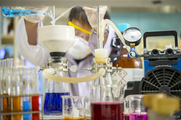 Scientists pour a solution to filter into the filter Buchner funnel to separate the solution from the sediment through a vacuum pump. in the chemical laboratory.