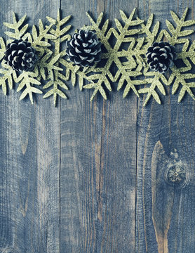 Christmas wooden background with decorative snowflakes and pine cones. Top view with copy space. Empty space for your text.
