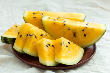 Yellow watermelon sliced on wooden background