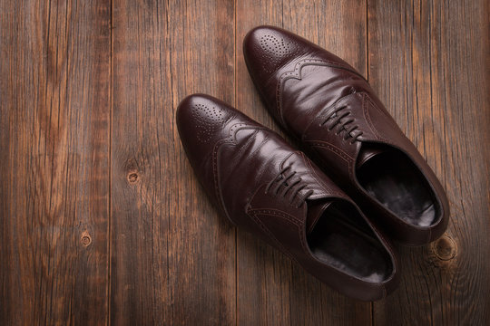 Men's brown shoes on a wooden background