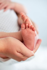 Baby feet in mother's hands. The concept of motherhood