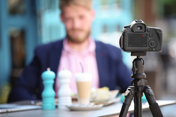 Young blogger recording video in cafe