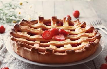 Delicious strawberry pie on table