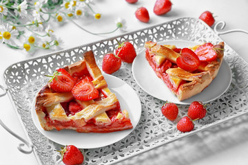 Plates with delicious strawberry pie on tray