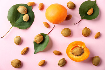 Composition with apricots and kernels on color background