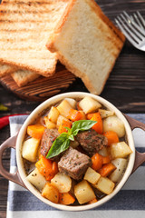 Casserole with tasty meat and potatoes on table