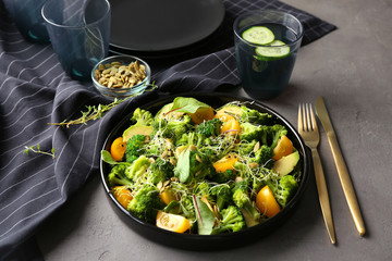 Superfood salad with broccoli and yellow tomato on grey background
