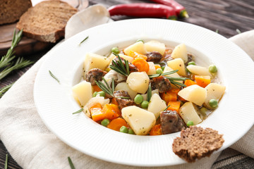 Plate with tasty meat and potatoes on table