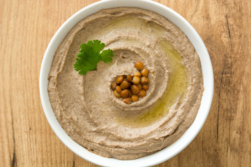 Lentil hummus in bowl on wood