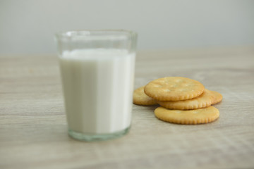 MILK GLASS AND CRACKERS
A glass of milk with pile of crackers on the wood top table. 