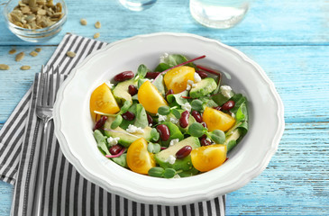 Superfood salad with yellow tomato, beans and zucchini on wooden background