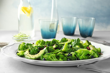 Superfood salad with avocado, beans and broccoli on white ceramic plate in kitchen