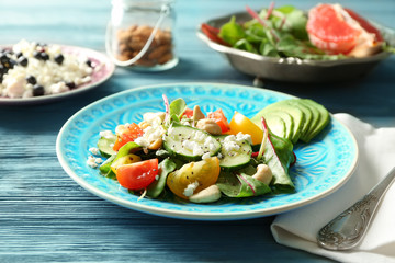 Superfood salad with cucumber, zucchini and tomato on blue plate in kitchen