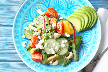 Superfood salad with cucumber, zucchini and tomato on blue wooden background
