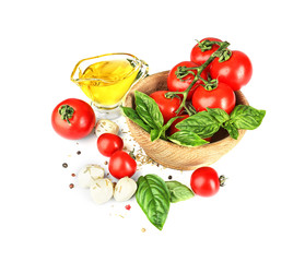 Composition with oil, cherry tomatoes, mozzarella cheese balls and green fresh organic basil isolated on white