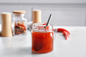 Composition with chili sauce on table