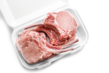 Raw ribs in container on white background