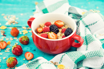 Bowl of oatmeal porridge with fresh berries: blackberry, strawberry and raspberry on . Healthy food for breakfast