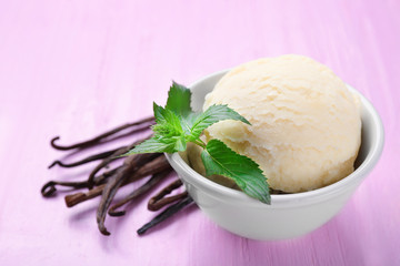 Delicious vanilla ice cream in white ceramic bowl on color background