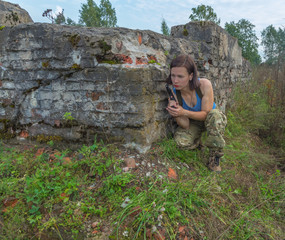 a stone wall the girl with the pistol.