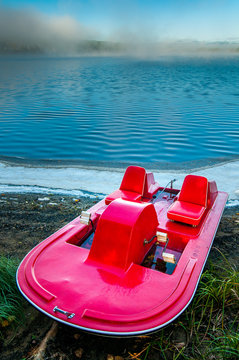 A pedal boat stranded at the edge of a lake early in the morning in Saint-aimé-des-Lacs in Quebec,  Canada