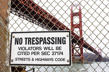 A 'No Trespassing' sign in Fort Point, with the Golden Gate Bridge in the background