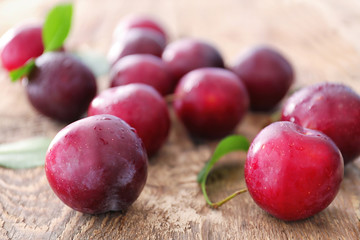 Fresh ripe plums on wooden table, closeup