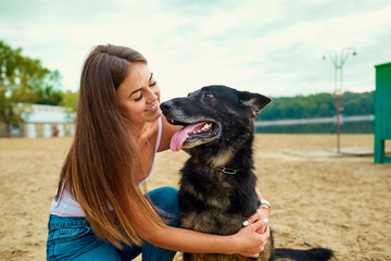 Portrait of a girl with a dog by a German shepherd in the summer. - Powered by Adobe