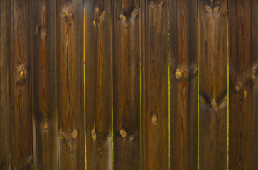 Fence from old wet planks with gaps between planksce