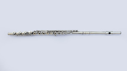 A silver french flute laying horizontally on a white background