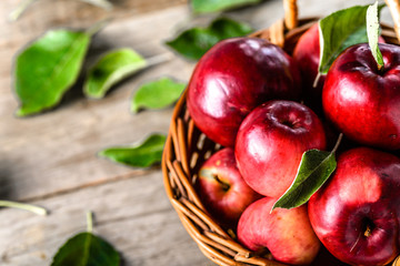 Red apples on wooden table, basket of red apple fruits on local farmer market