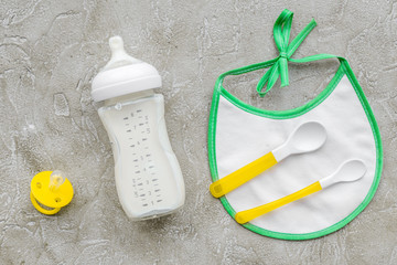 children feeding with breastmilk or infant formula powdered baby milk and toys on gray background top view