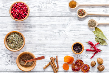 Colorful dry herbs and spices for cooking food light wooden kitchen table background top view space for text