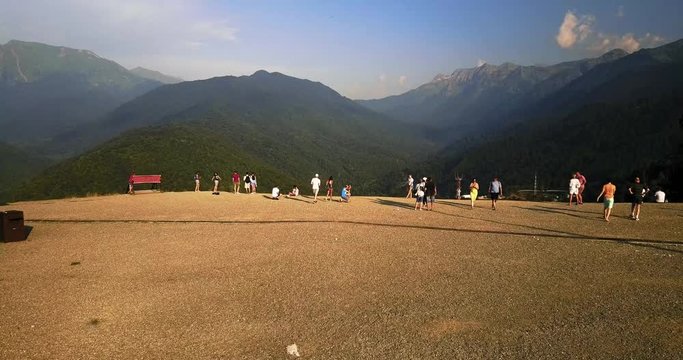 People walk against the backdrop of mountain valley. Rosa Khutor