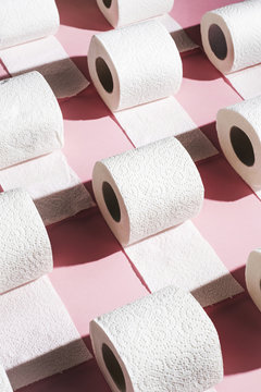 Toilet paper rolls on pink background.