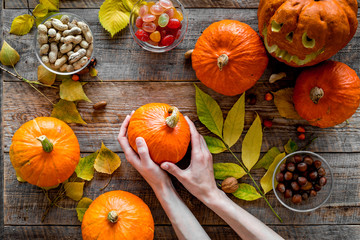 Pumpkin harvest. Pumpkins near nuts and autumn leaves on wooden background top view