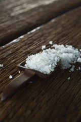Naklejka premium Salt in spoon on wooden table