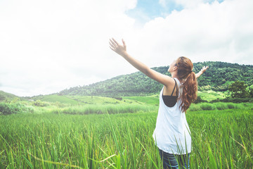 Asian women travel relax in the holiday. on a green pasture.