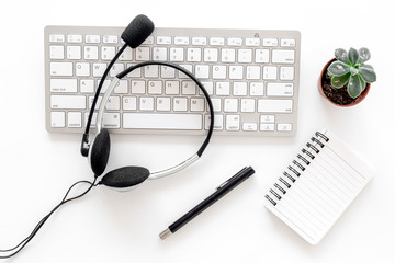 Workplace in call center. Headphones on keyboard and notebook on white background top view