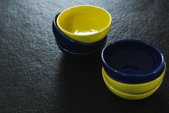 Yellow and blue plastic bowl on black background