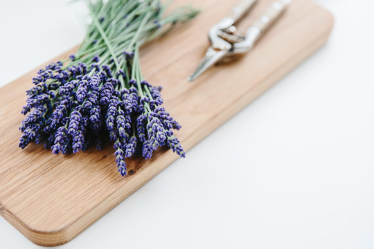 Cut lavender flowers on a wooden board.