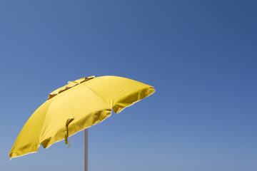 Yellow sun umbrella against the blue sky