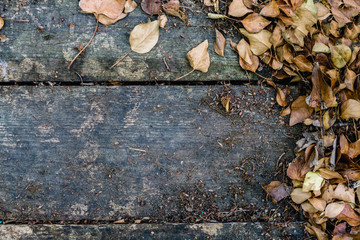 Top view background texture with old wooden table and yellow autumnal leaves